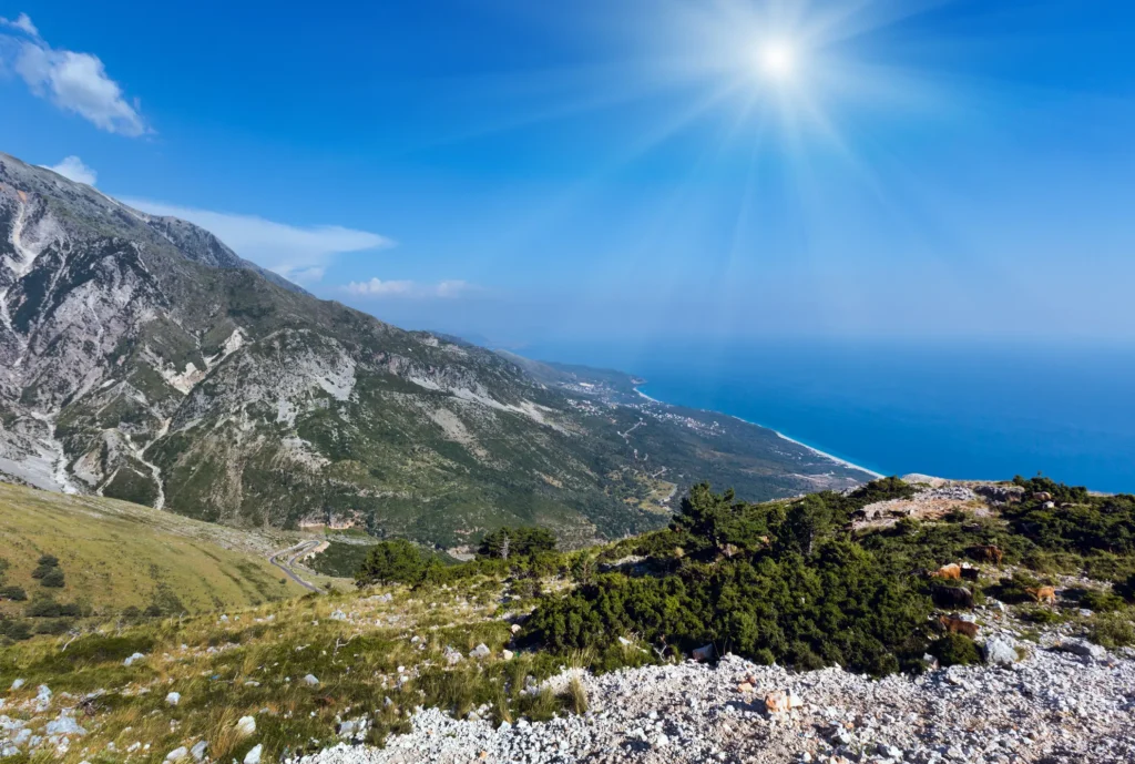 Aerial view of the Llogara Pass switchback road descending through the mountains toward the Albanian Riviera coastline